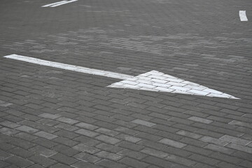 white arrow on gray asphalt, turn left, turn right, abstract white lines on asphalt, background of asphalt texture and white lines