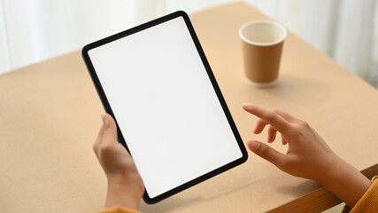 Woman hand holding digital tablet with white blank screen for advertisement. Close up view