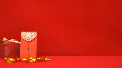 looping of Chinese Lunar New Year red background. ancient Chinese gold bar, red gift box with golden bow, red envelope, ang pow for giving money on Chinese new year celebration, shadow foliage sway 