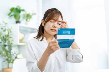 通帳を見て悩む日本人女性