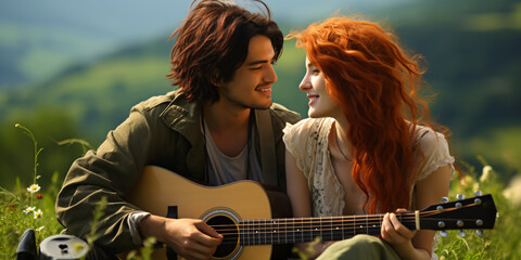 a young happy couple with a guitar sitting on a mountain meadow in summer