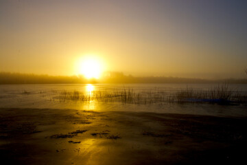 Fototapeta na wymiar Sunrise in yellow hazy dawn on a cold January day
