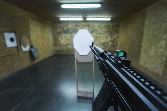 Tactical ak 74m rifle shooting at a paper target at a shooting range.