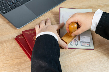 Close-up of female border patrol officers meticulously inspecting foreign passports, visa permits...