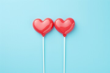 Valentine day concept with two broken red lollipop hearts on pastel blue background top view. Flat lay style