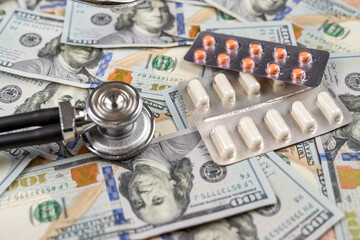 stethoscope medical treatments pills with dollar bills on desk