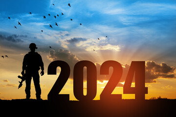 Silhouette of soldier and 2024 against the sunrise or sunset.