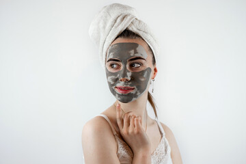 pretty sexy woman applying clay black mask on white background