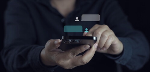 hand using smartphone typing Live chat chatting and social network concepts, chatting conversation working at home in chat box icons pop up. Social media marketing technology concept.