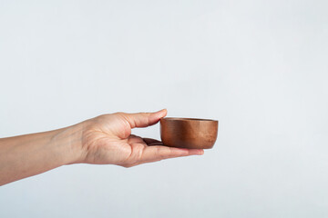 Cup wooden in hand on white background
