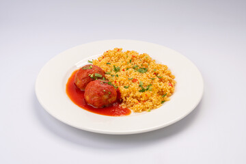 Business lunch. Meat balls in tomato sauce with a side dish of cereals and vegetables on a white background