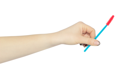 Silicone eyelash extension brush in hand, outstretched hand with silicone eyelash extension brush isolated from background