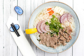 Beef pho vietnamese soup with onion, rice noodles, garlic, chilli and coriander