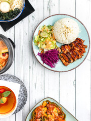 flat lay picture of sliced grilled marinated chicken with cabbage and rice