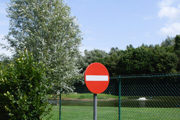 Sign prohibiting entry into the park area in nature. Fenced seating area