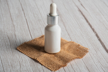 Fototapeta na wymiar Plastic white tube for cream or lotion. Skin care or sunscreen cosmetic on white wood background.