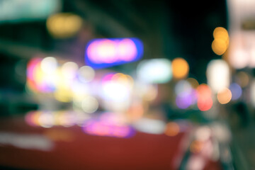 abstract defocused background of traffic on street of nightlife city, view from red taxi roof at...