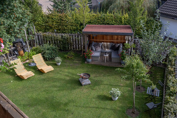 Garden with furniture, chairs and barbecue on a sunny summer day