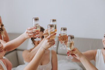 Photo bride with her friends drinking champagne from glasses. Cropped shot of a beautiful young...