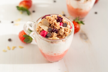Yogurt with red fruit granola with strawberry cream, almonds and chocolate chips. Healthy snack idea for children.