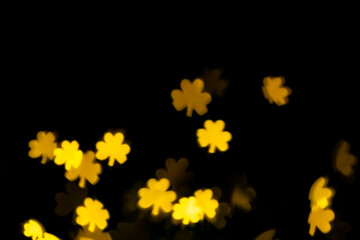 glare, bokeh, lights in the shape of clover leaves on a black background. for overlay