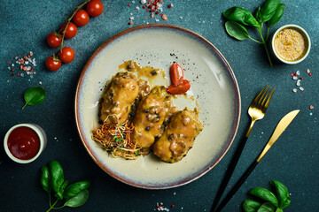 Dumplings made of cabbage, rice and meat with mushroom gravy on a plate. On a black stone background.