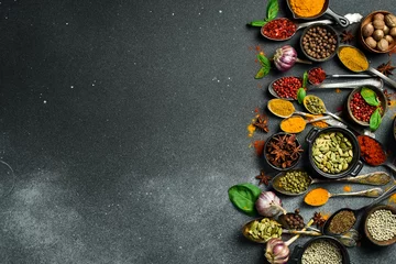 Poster Variety of spices and herbs on kitchen table. Top view. Free space for text. © Yaruniv-Studio