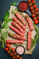 Raw Lyulya kebab with spices and herbs, ready for cooking. On a dark stone background. Top view....