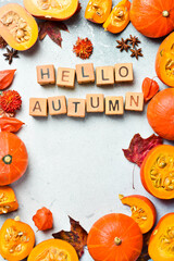 Banner: hello autumn. Orange pumpkins on a stone table, holiday decoration. Pumpkin menu. Top view.
