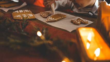 Children decorate gingerbread house, cozy homely Christmas atmosphere