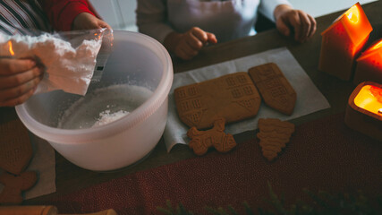 Children decorate gingerbread house, cozy homely Christmas atmosphere