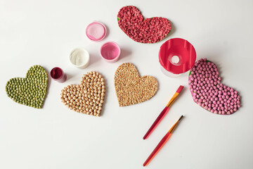 Children's creativity from heart-shaped cereals top view, fine motor skills development concept