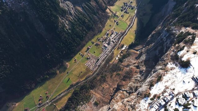 Aerial view of deep Switzerland mountain valley, city and buildings on edge
