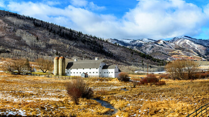 White Barn with Snow-Capped Mountain Panorama - 4K Ultra HD Image of Winter Scenery 