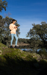 Sporty woman looking at cell phone in nature