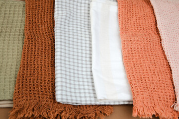 Different texture and colour kitchen towels, waffle and linen on a brown background. Top view