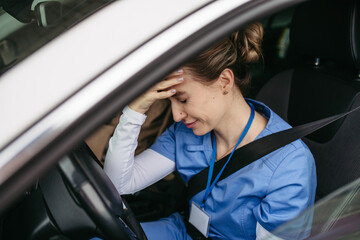 Nurse crying in car, going home after hard work day. Female doctor feeling exhausted, frustrated,...