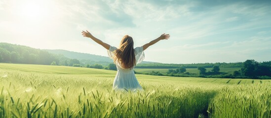 girl in green field with open arms dancing and enjoying nature. Creative Banner. Copyspace image - obrazy, fototapety, plakaty