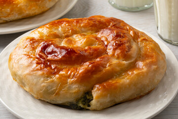 Plate with fresh homemade baked Turkish borek with spinach and cheese close up 