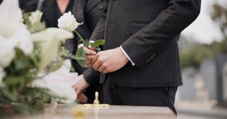 Hand, rose and a person at a funeral in a graveyard in grief while mourning loss at a memorial...