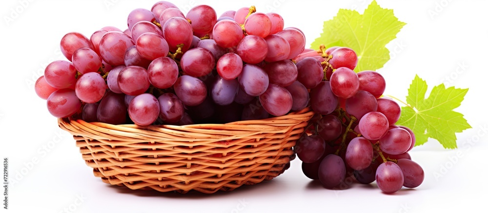 Poster Grapes with leaves in wicker basket Isolated on white background. Creative Banner. Copyspace image
