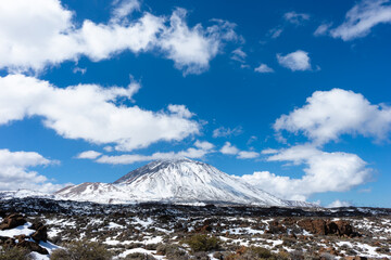 The iconic Pic Tel Teide covered with snow in a blue sky and beautiful white clouds. Tenerife, Canary Islands, Spain. - 722918139
