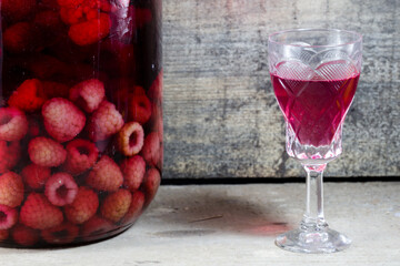 raspberry tincture in a jar and a glass