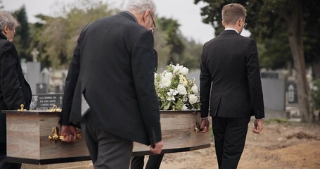 Coffin, men and pallbearers walking at graveyard ceremony outdoor at burial tomb. Death, grief and...