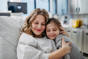 Daughter visiting mother in hospital after surgery. Emotional support from family for patients in hospital.