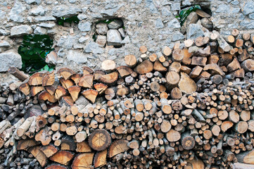 Countryside: a pile of chopped wood stacked against the stonewall.