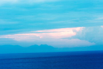 Fototapeta premium Bizarre formation of clouds in a pale blue sky over the sea. 