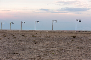 Street lamps in a row beyond the beach.