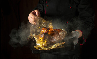 The chef removes the plastic pouch from the duck after baking or sous vide cooking. Concept of...