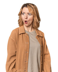 Blonde middle-aged Caucasian woman in studio being shocked because of something she has seen.